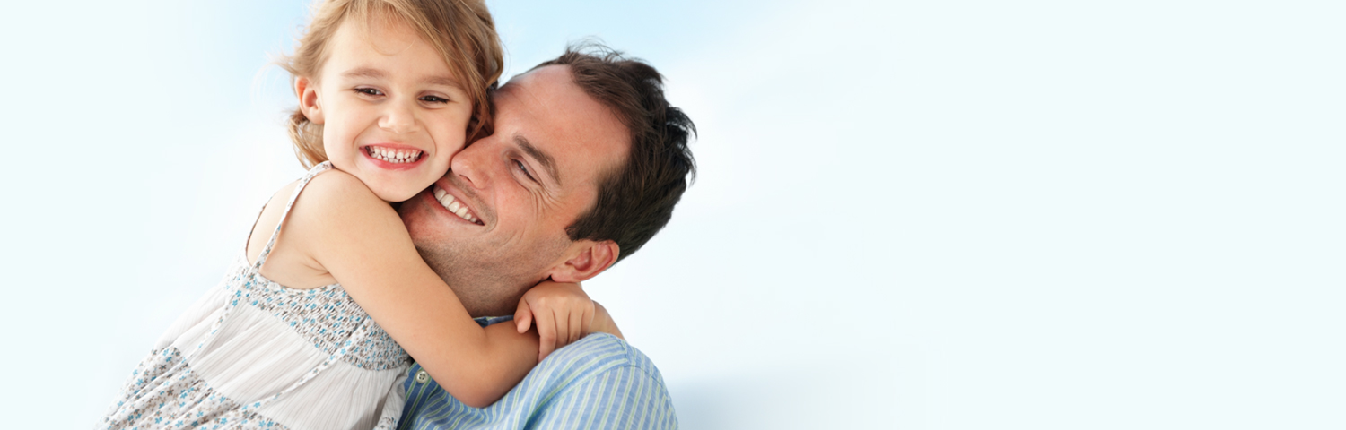 Father hugging daughter after dental treatment for the family